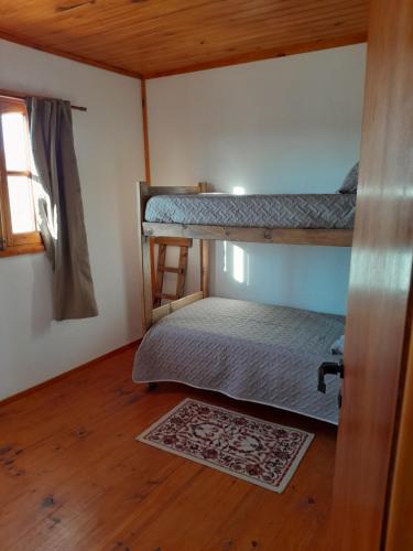 Una habitación con dos literas y suelo de madera. en Las Lambertianas, en Colonia Elía