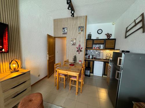 Il comprend une cuisine équipée d'une table et d'un réfrigérateur. dans l'établissement La belle échappée, à Prénatier