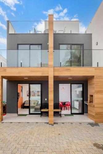 a modern house with glass doors and a patio at Casa Pé na Areia a 10m da Praia! Imperdível! in Olivença