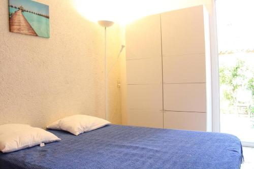 - une chambre avec un lit bleu et 2 oreillers dans l'établissement Maison 3 pièces 6 couchages PORT LA NOUVELLE PN000-127, à Port-la-Nouvelle