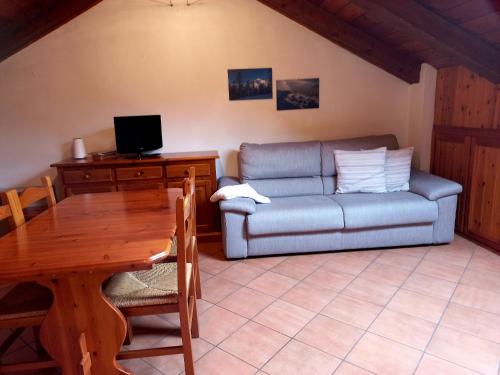 a living room with a couch and a table at Mansarda Bardonecchia in Bardonecchia