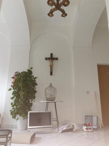 a room with a tv and a cross on the wall at Locanda EL TORO in Arnoldstein