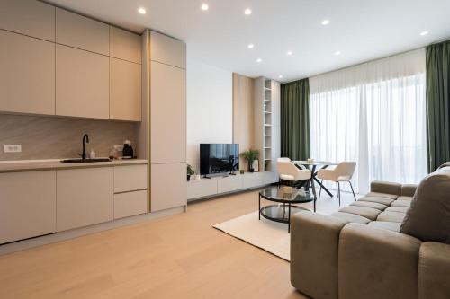 a living room with a couch and a table at Caffe Luxury king bed Entire Apartment, underground Parking near Promenada Bussiness Center in Bucharest