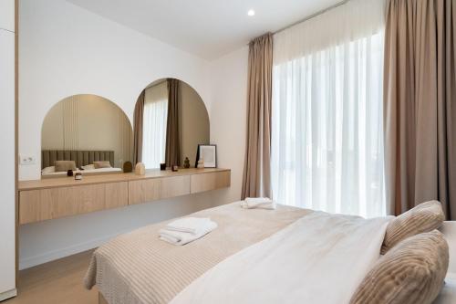 a bedroom with a large bed and a large mirror at Caffe Luxury king bed Entire Apartment, underground Parking near Promenada Bussiness Center in Bucharest