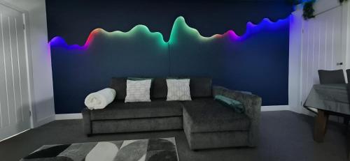 a living room with a couch and a blue wall at Modern Spacious Apartment Steps from City Centre in Norwich
