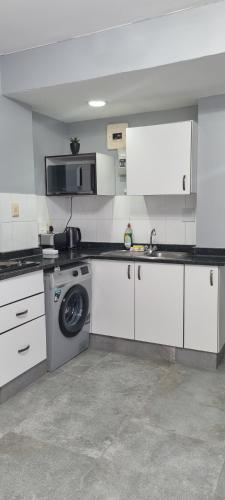 a kitchen with a sink and a washing machine at Oceanic Unit 67 - North Beach in Durban