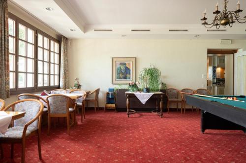 a dining room with a pool table and chairs at Seiler au Lac in Bönigen