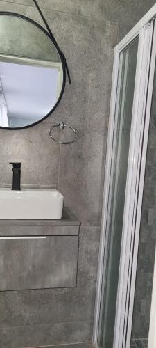 a bathroom with a sink and a mirror at Oceanic Unit 67 - North Beach in Durban