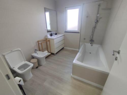 Un baño con inodoro, bañera y lavabo. en Azores Blue Bay II, en Madalena