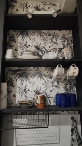a shelf with plates and dishes on it at ChezEl Safari in Sillé-le-Guillaume