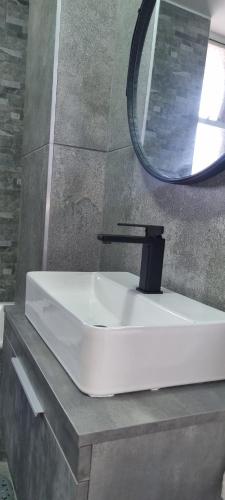 a white sink and a mirror in a bathroom at Oceanic Unit 67 - North Beach in Durban