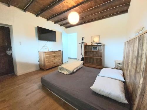 - une chambre avec un lit, une commode et une télévision dans l'établissement Beautiful renovated farmhouse of 250m with 3400m of garden, à Saint-Savin