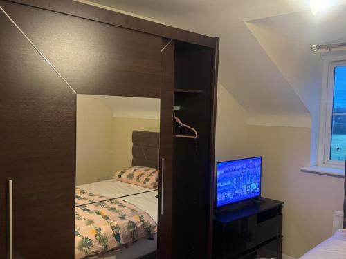 a bedroom with a mirror and a bed and a television at Komegloba Mega room in Manchester