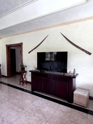 a living room with a flat screen tv on a wall at Paparadise in Papara