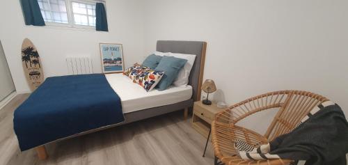 a small bedroom with a bed and a chair at Lé Luquentia, demeure de charme, piscine, grand jardin, spa, billard in Gujan-Mestras