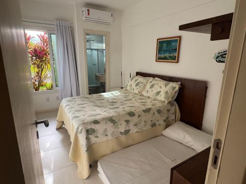 ein kleines Schlafzimmer mit einem Bett und einem Fenster in der Unterkunft Casa à Beira-Mar em Itacimirim, Viva o Paraíso! in Camassari