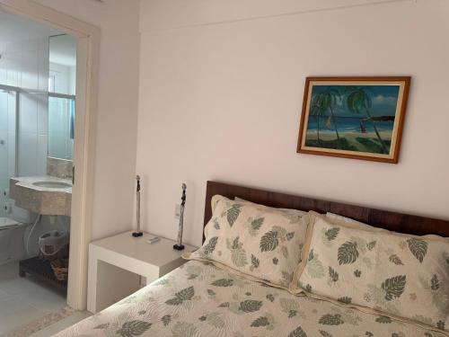 ein Schlafzimmer mit einem Bett und einem Bild an der Wand in der Unterkunft Casa à Beira-Mar em Itacimirim, Viva o Paraíso! in Camassari