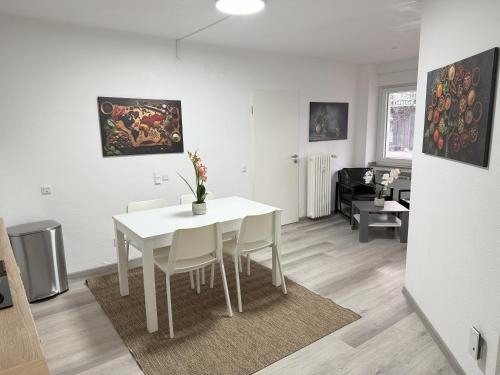 a white dining room with a white table and chairs at Zentral gelegene Zimmer mit Gemeinschaftsküche und -bad in Herne