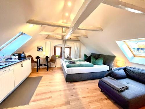 a bedroom with a bed and a couch in a room at Ysenberc Apartments in Moritzburg