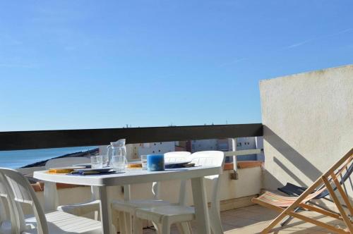 une table et des chaises sur un balcon avec vue sur l'océan dans l'établissement Appartement 3 pièces CAP D'AGDE CT370-136, au Cap d'Agde