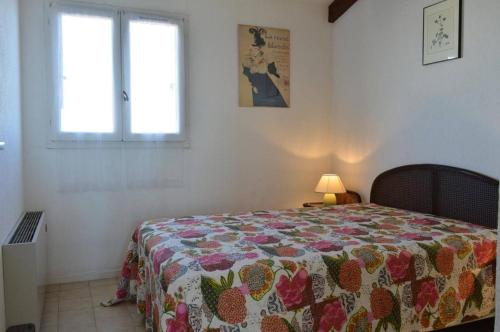 une chambre avec un lit avec une couette dessus dans l'établissement Appartement 3 pièces CAP D'AGDE CT370-136, au Cap d'Agde