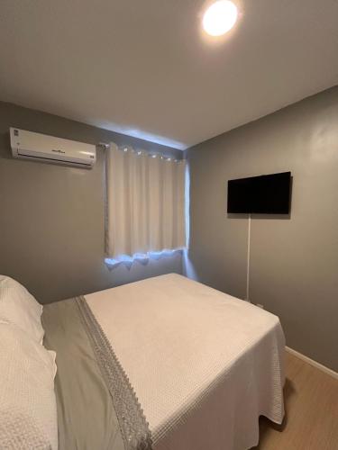 a bedroom with a bed and a flat screen tv at Apartamento Cop 30 in Ananindeua
