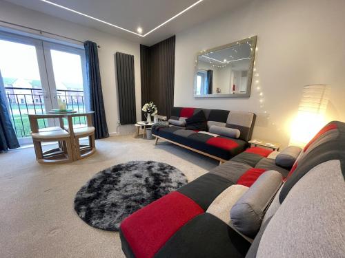 a living room with a couch and a mirror at Florence Coach-House-Parking-WIFI King bedroom & double bedroom in Peterborough