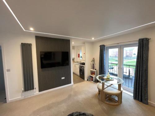 a living room with a table and a large window at Florence Coach-House-Parking-WIFI King bedroom & double bedroom in Peterborough