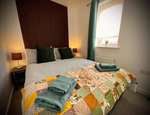 a bedroom with a bed with towels on it at Florence Coach-House-Parking-WIFI King bedroom & double bedroom in Peterborough