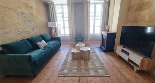 a living room with a blue couch and a flat screen tv at 4- Hypercentre, FREE Parking, Clim, Wifi, Netflix in Libourne