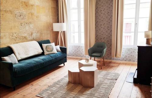 a living room with a green couch and a chair at 4- Hypercentre, FREE Parking, Clim, Wifi, Netflix in Libourne