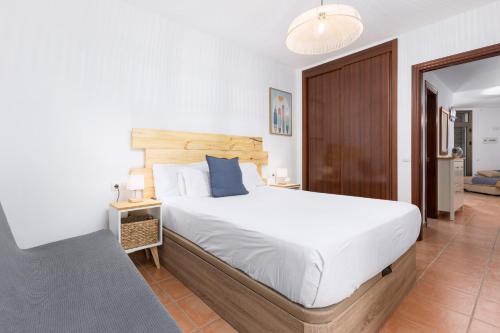 Un dormitorio con una cama grande con cabecero de madera. en 2BR El Cotillo House - Private Terrace, en Cotillo