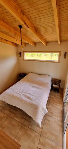 a bedroom with a bed in a room with a window at AltaVista Lago Ranco in La Unión