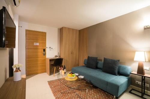 a living room with a blue couch and a table at Beyond Suite in Bangkok