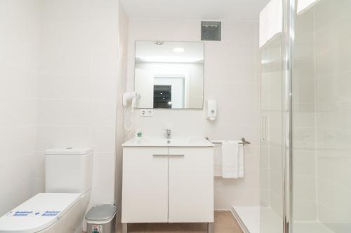 Un baño blanco con inodoro y lavabo. en BET Apartments - Abastos, en Valencia
