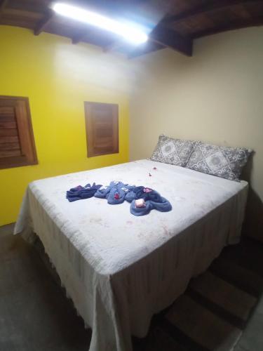 a bedroom with a bed with clothes on it at Chales Da Mata in Fortim