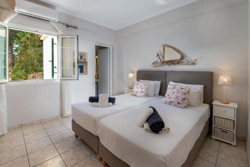 two beds in a bedroom with two windows at Dolphin House by the sea in Porto Ozias
