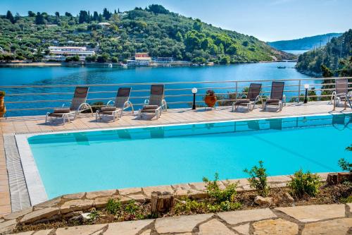 a swimming pool with chairs and a view of a lake at Dolphin House by the sea in Porto Ozias
