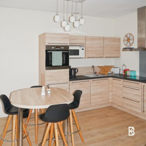 une cuisine avec une table et des chaises en bois dans l'établissement L'Échapée Z'Aisne, à Saint-Quentin