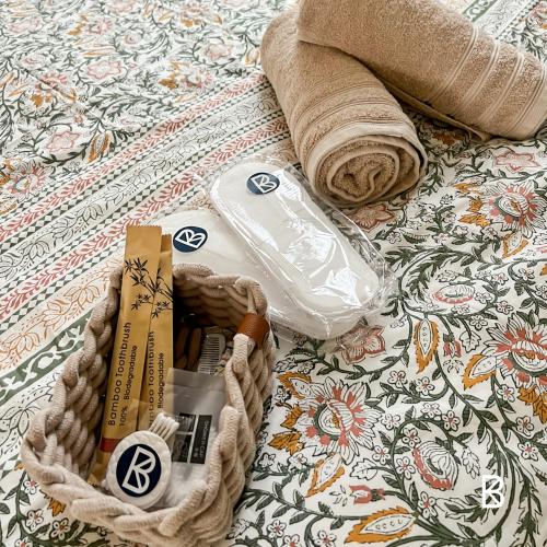 - un panier d'articles sur un lit avec une serviette dans l'établissement L'Échapée Z'Aisne, à Saint-Quentin