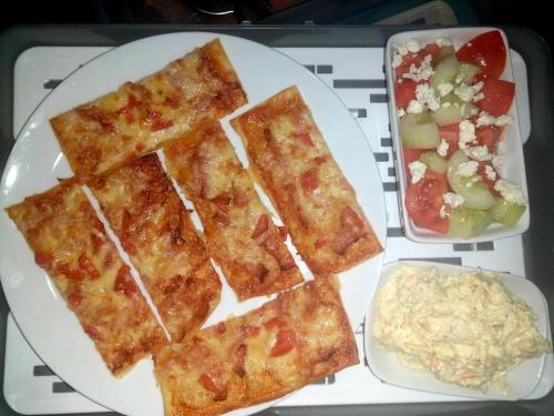 a white plate of food with a salad and pizza at Lina Gio Apart in Karlovo