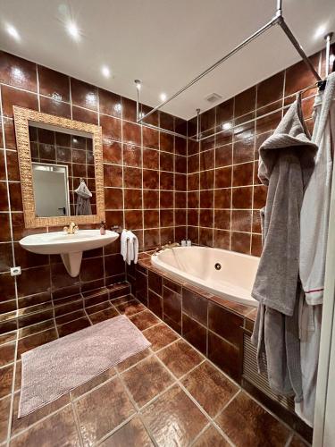 a bathroom with a tub and a sink and a mirror at Briller Palais in Wuppertal