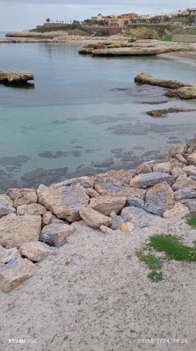 a group of rocks on the shore of a body of water at b&b Casa Balai 72 a 100 mt dal mare in Porto Torres