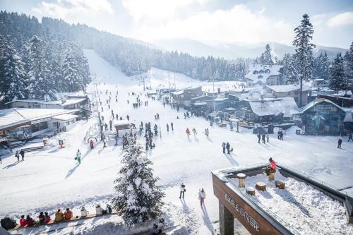 a group of people skiing down a snow covered slope at Rila Hotel Borovets in Borovets