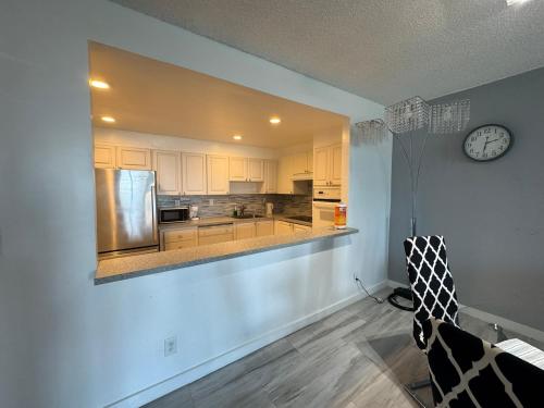 a kitchen with white cabinets and a clock on the wall at Family Stay Ocean Reserve Resort Sunny Isles in Sunny Isles Beach