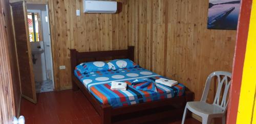 a bedroom with a bed and a chair in it at bahia del sol - ladrilleros in Buenaventura