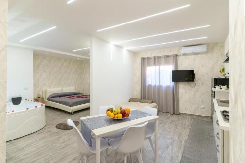 a living room with a table and chairs and a bedroom at Belsito Suite in Misterbianco