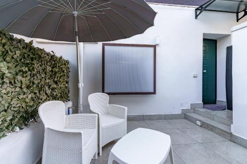 a patio with a table and chairs and an umbrella at Belsito Suite in Misterbianco
