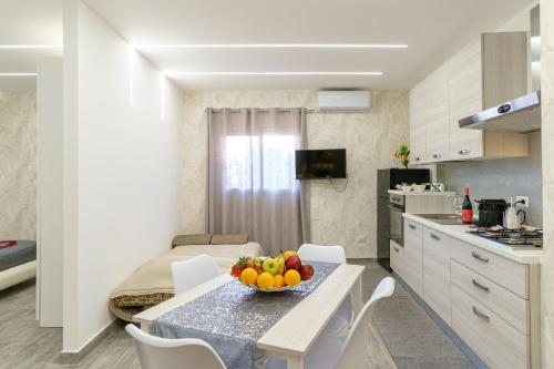 a kitchen and dining room with a bowl of fruit on a table at Belsito Suite in Misterbianco