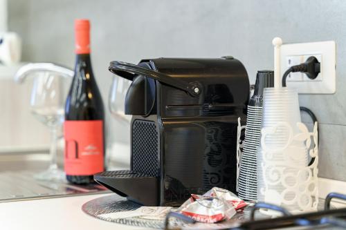 a toaster sitting on a counter with a bottle of wine at Belsito Suite in Misterbianco